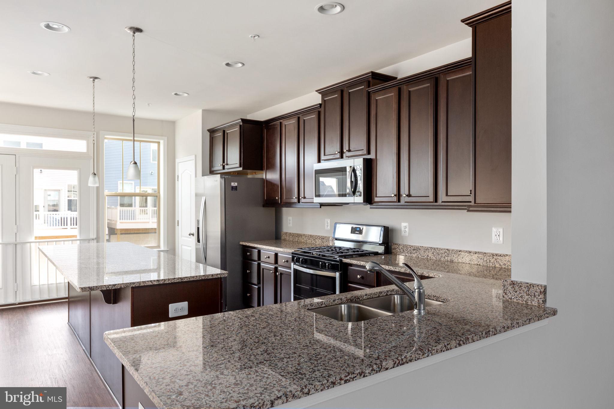 1805 Evans Road Frederick, MD 21702 - Photo 4 of 21 a kitchen with stainless steel appliances granite countertop a sink refrigerator and microwave