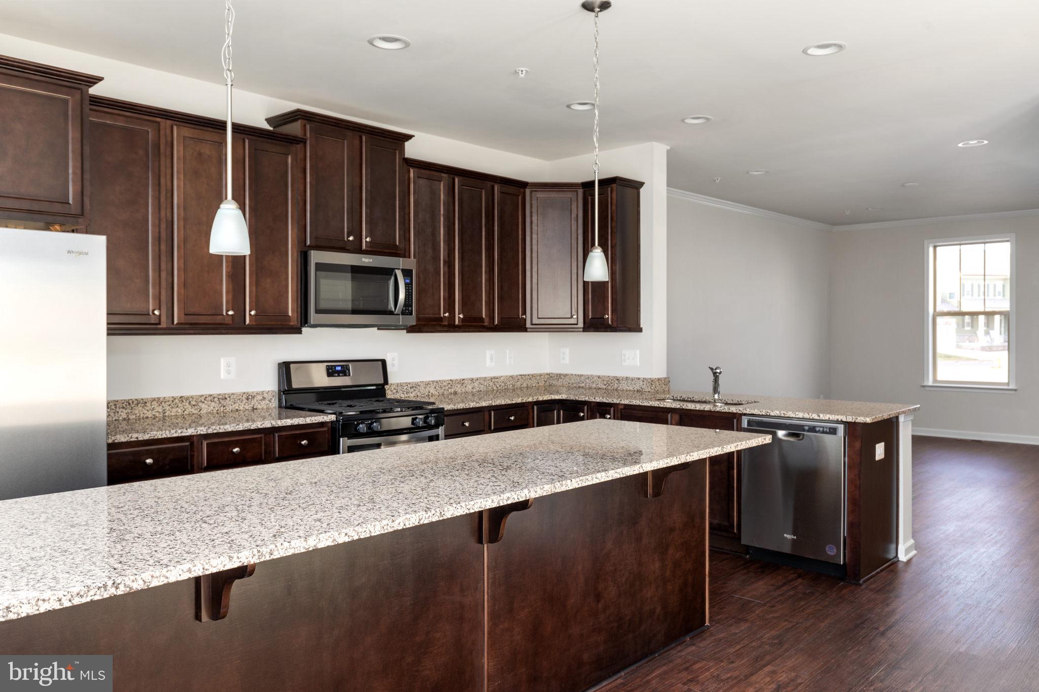 1805 Evans Road Frederick, MD 21702 - Photo 7 of 21 a kitchen with stainless steel appliances granite countertop a sink a stove a refrigerator a microwave oven with wooden floor