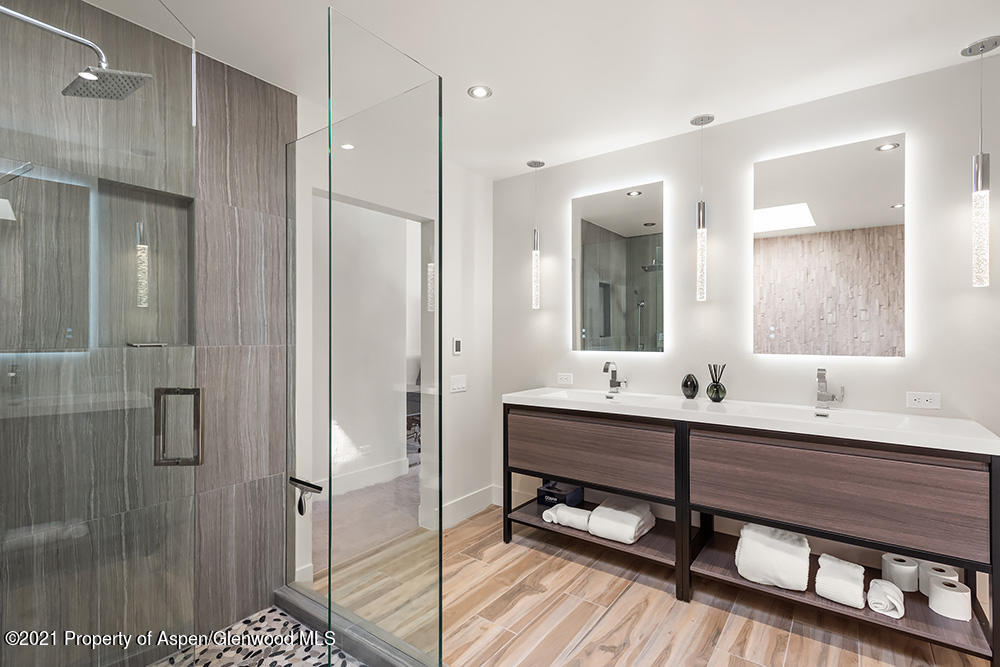 800 Ridge Road, Unit 12 Snowmass Village, CO 81615 - Photo 13 of 27 a bathroom with a double vanity sink a mirror and a shower