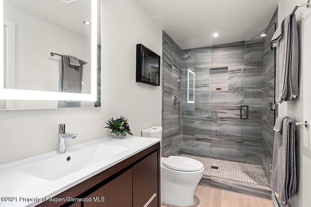 800 Ridge Road, Unit 12 Snowmass Village, CO 81615 - Photo 9 of 27 a bathroom with a sink a toilet a mirror and shower
