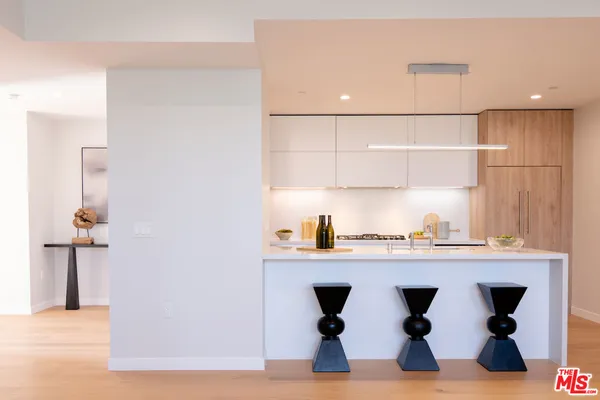 a kitchen with stainless steel appliances granite countertop a sink and a refrigerator