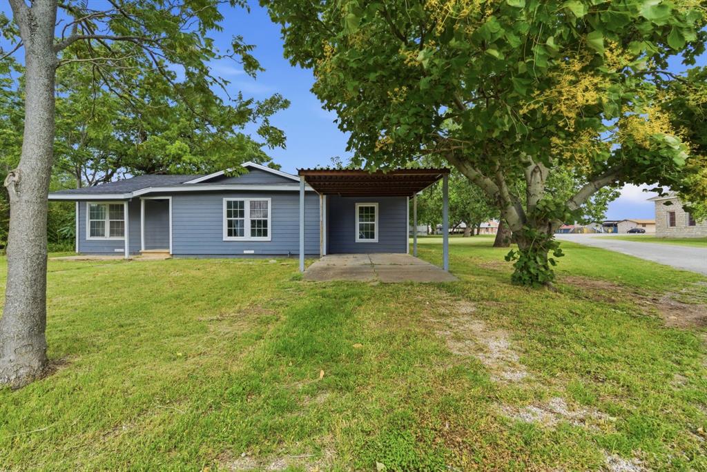 203 North Kickapoo Street Lipan, TX 76462 - Photo 4 of 28 a front view of a house with garden