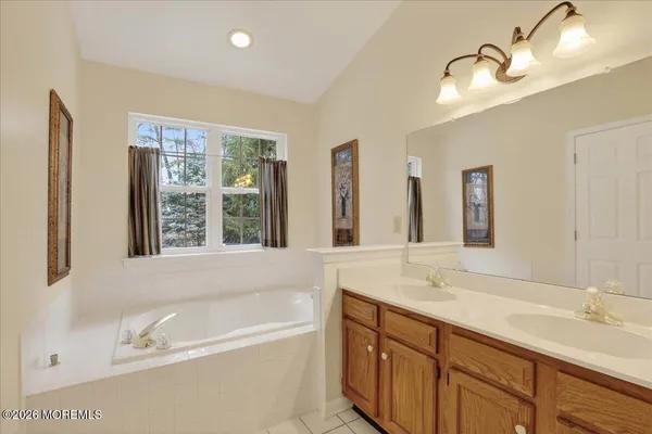 a bathroom with a tub a sink and a window