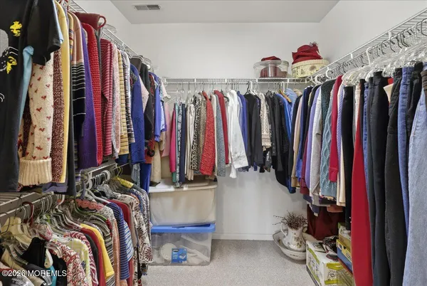 a view of walk in closet with clothes