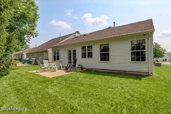 a view of a house with backyard and sitting area
