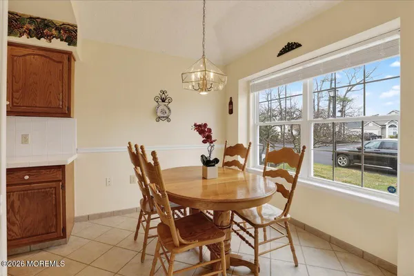 a dining room with furniture a chandelier and window