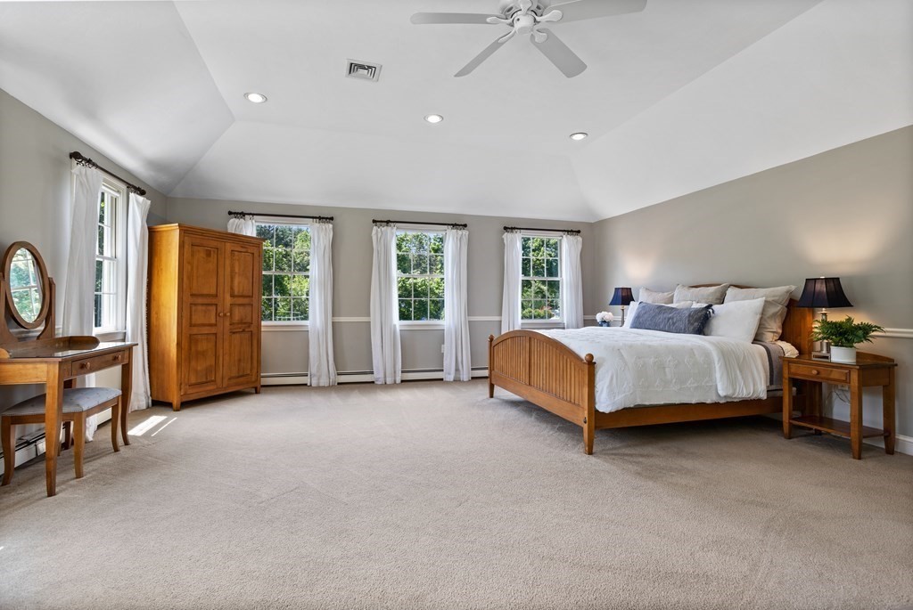 24 Devincent Drive Stow, MA 01775 - Photo 20 of 39 a spacious bedroom with a bed a table and large windows