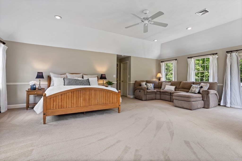 24 Devincent Drive Stow, MA 01775 - Photo 22 of 39 a bedroom with a bed a couch and a chandelier