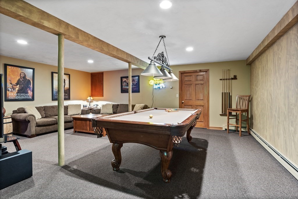 24 Devincent Drive Stow, MA 01775 - Photo 28 of 39 a dining hall with stainless steel appliances kitchen island granite countertop a table chairs and a refrigerator
