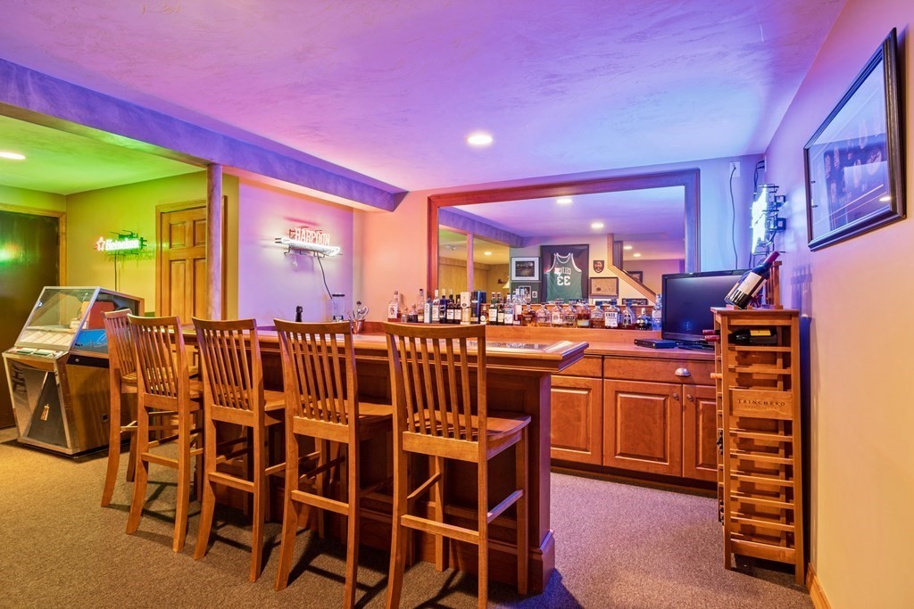 24 Devincent Drive Stow, MA 01775 - Photo 31 of 39 a kitchen with stainless steel appliances kitchen island granite countertop a table chairs and a refrigerator