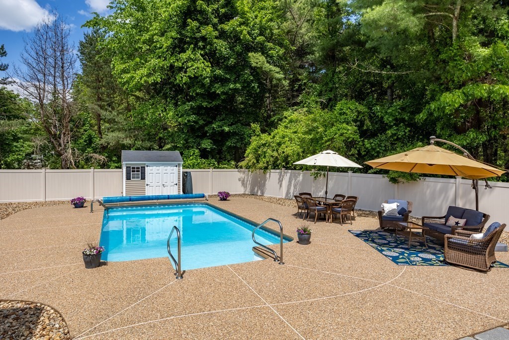 24 Devincent Drive Stow, MA 01775 - Photo 35 of 39 a patio with a table and chairs under an umbrella