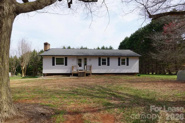 a front view of a house with yard and trees