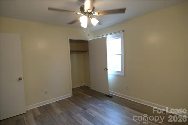 an empty room with windows and fan