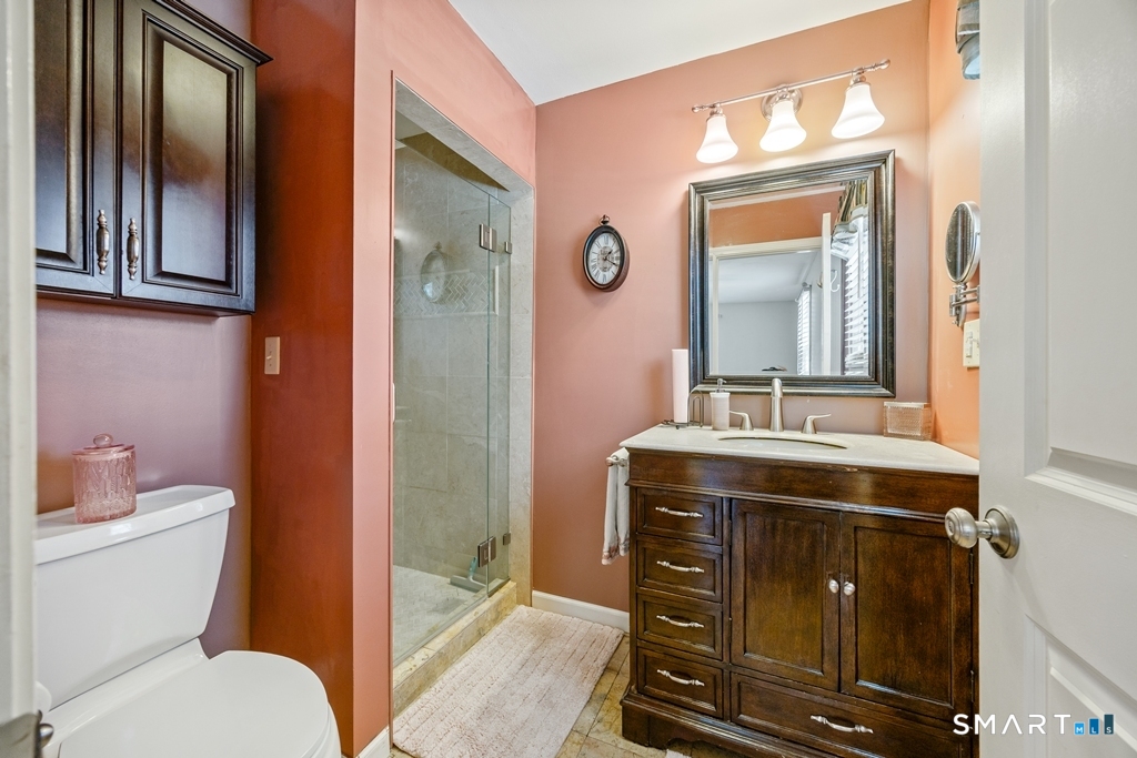 63 Lyman Road Wolcott, CT 06716 - Photo 41 of 70 a bathroom with a granite countertop toilet a sink and a mirror