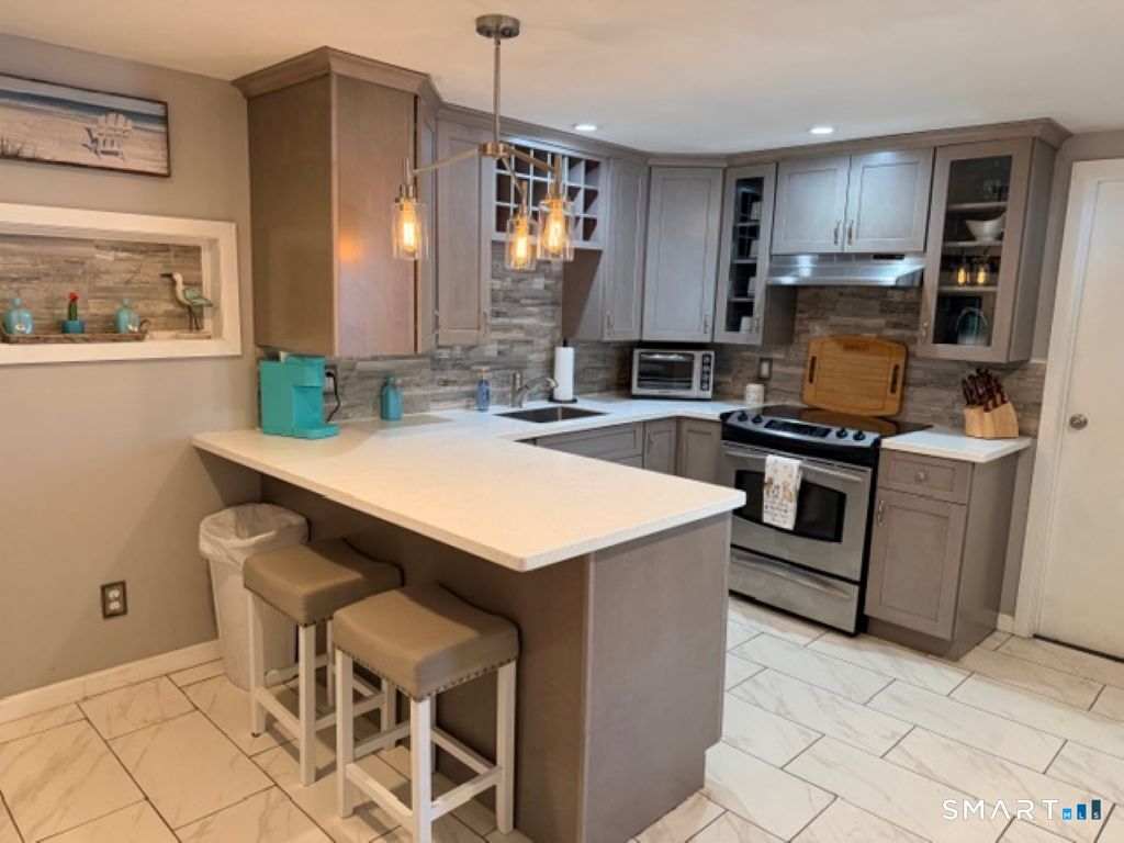 63 Lyman Road Wolcott, CT 06716 - Photo 56 of 70 a kitchen with granite countertop a sink stove and refrigerator