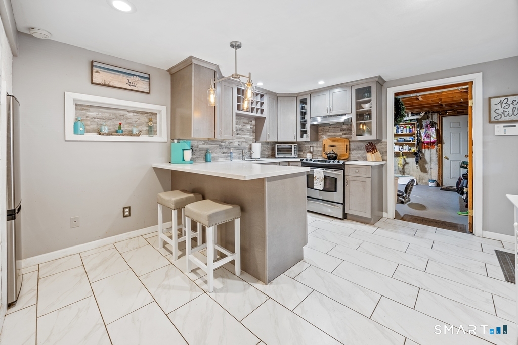 63 Lyman Road Wolcott, CT 06716 - Photo 61 of 70 a open kitchen with stainless steel appliances granite countertop a stove top oven a sink a dining table and chairs