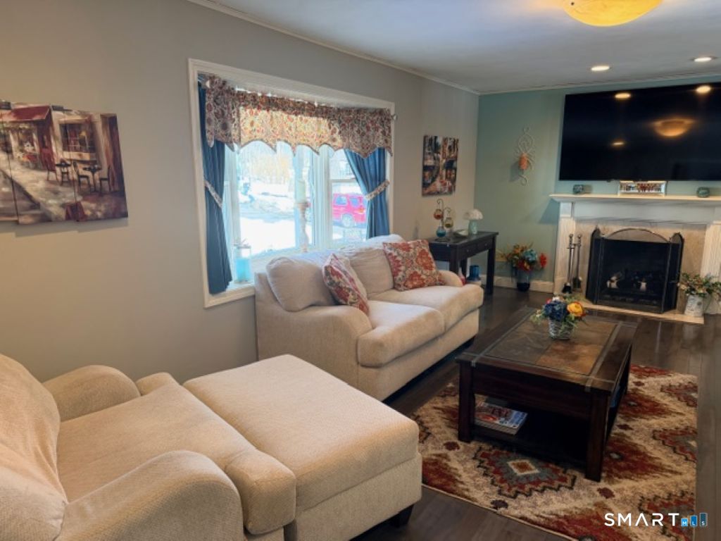 63 Lyman Road Wolcott, CT 06716 - Photo 8 of 70 a living room with furniture a flat screen tv and a fireplace
