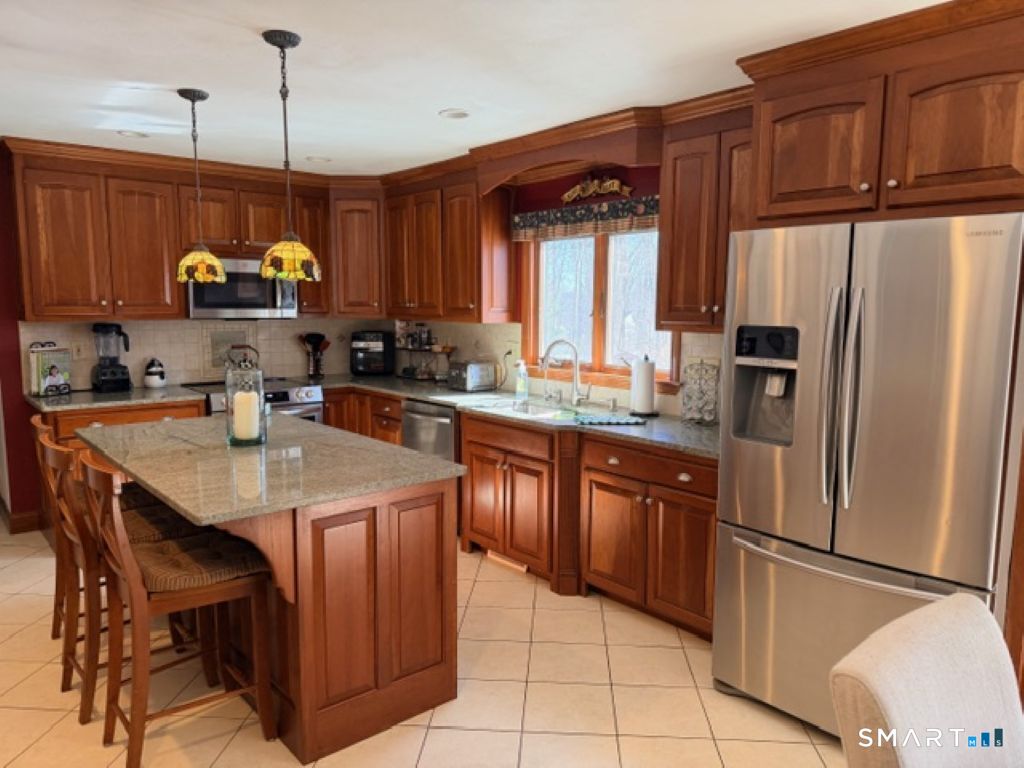 63 Lyman Road Wolcott, CT 06716 - Photo 10 of 70 a kitchen with stainless steel appliances granite countertop a sink refrigerator and cabinets
