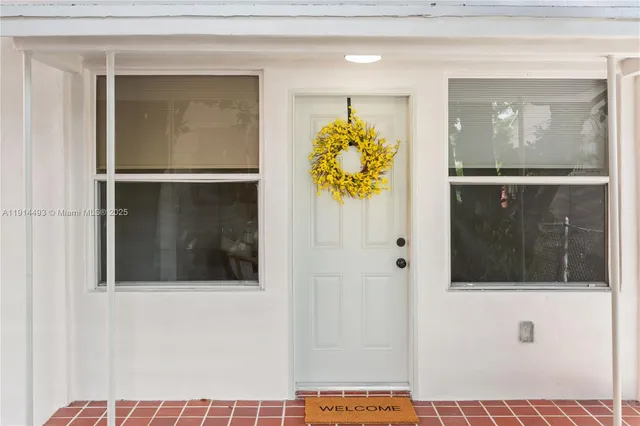 a view of a hallway with wooden floor and front door