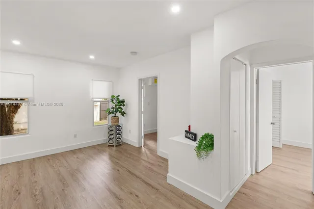 a room with wooden floor and a potted plant