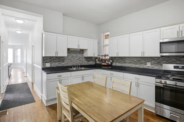 a kitchen with stainless steel appliances a stove a sink a microwave a refrigerator and cabinets