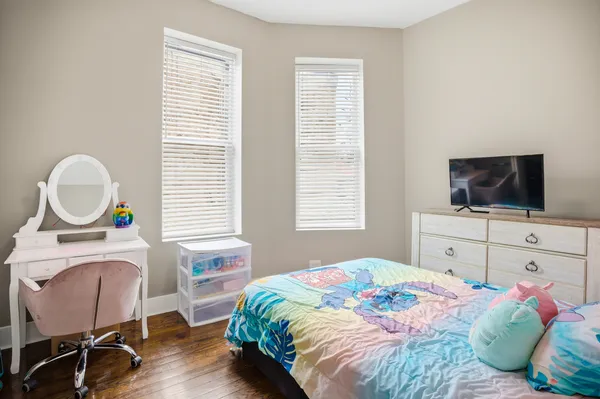 a bedroom with a bed window and a flat screen tv