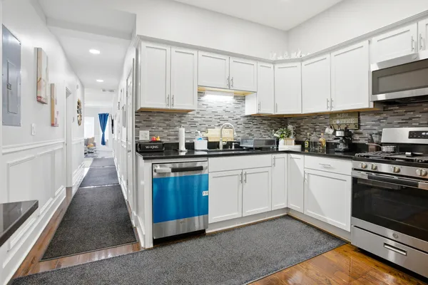 a kitchen with stainless steel appliances granite countertop a stove a sink and a white cabinets