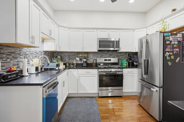 a kitchen with stainless steel appliances a refrigerator sink and microwave