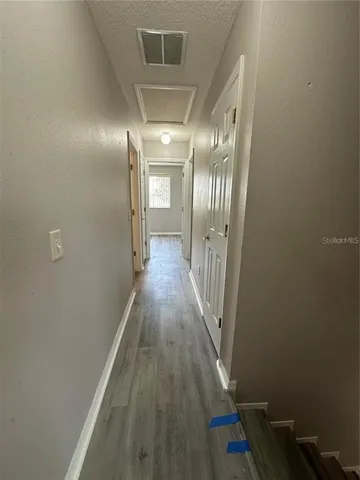 a view of a hallway with wooden floor