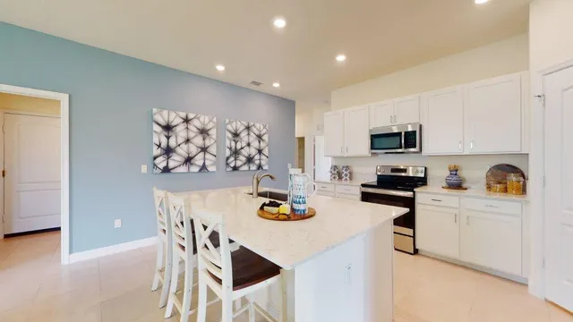 a kitchen with stainless steel appliances kitchen island granite countertop a sink cabinets and wooden floor