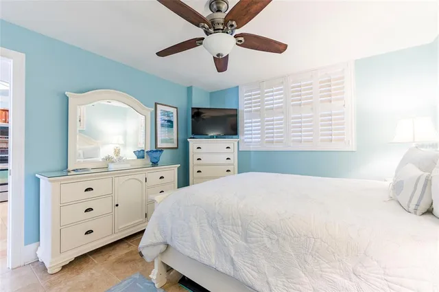 a spacious bedroom with a bed a window and a flat screen tv