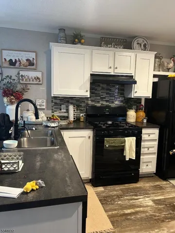 a kitchen with granite countertop a stove and a sink