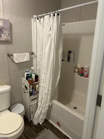 a white toilet sitting next to a bath tub