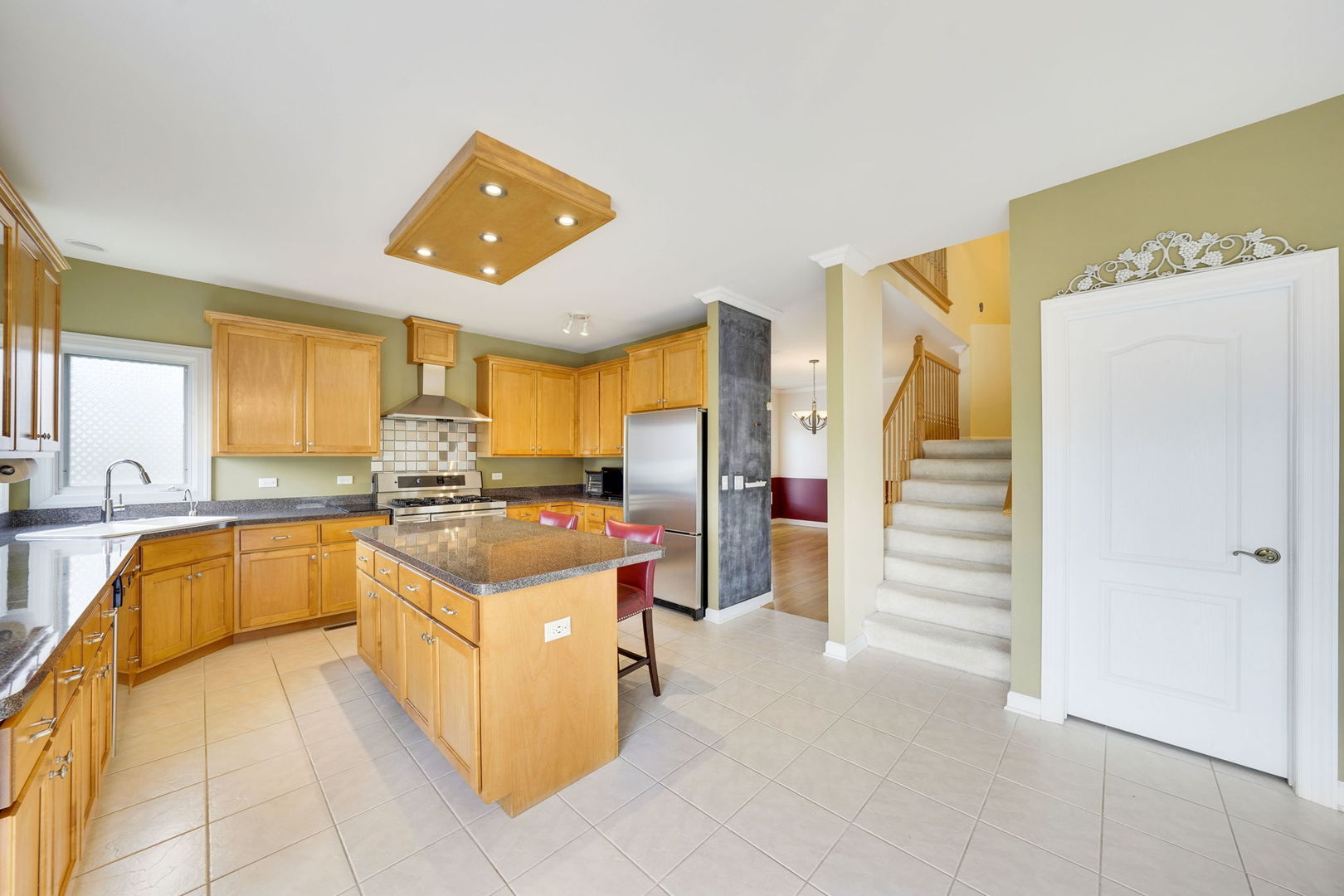 801 West Veterans Parkway Addison, IL 60101 - Photo 19 of 42 a kitchen with stainless steel appliances granite countertop a refrigerator and a sink