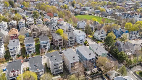 an aerial view of residential houses with outdoor space and swimming pool