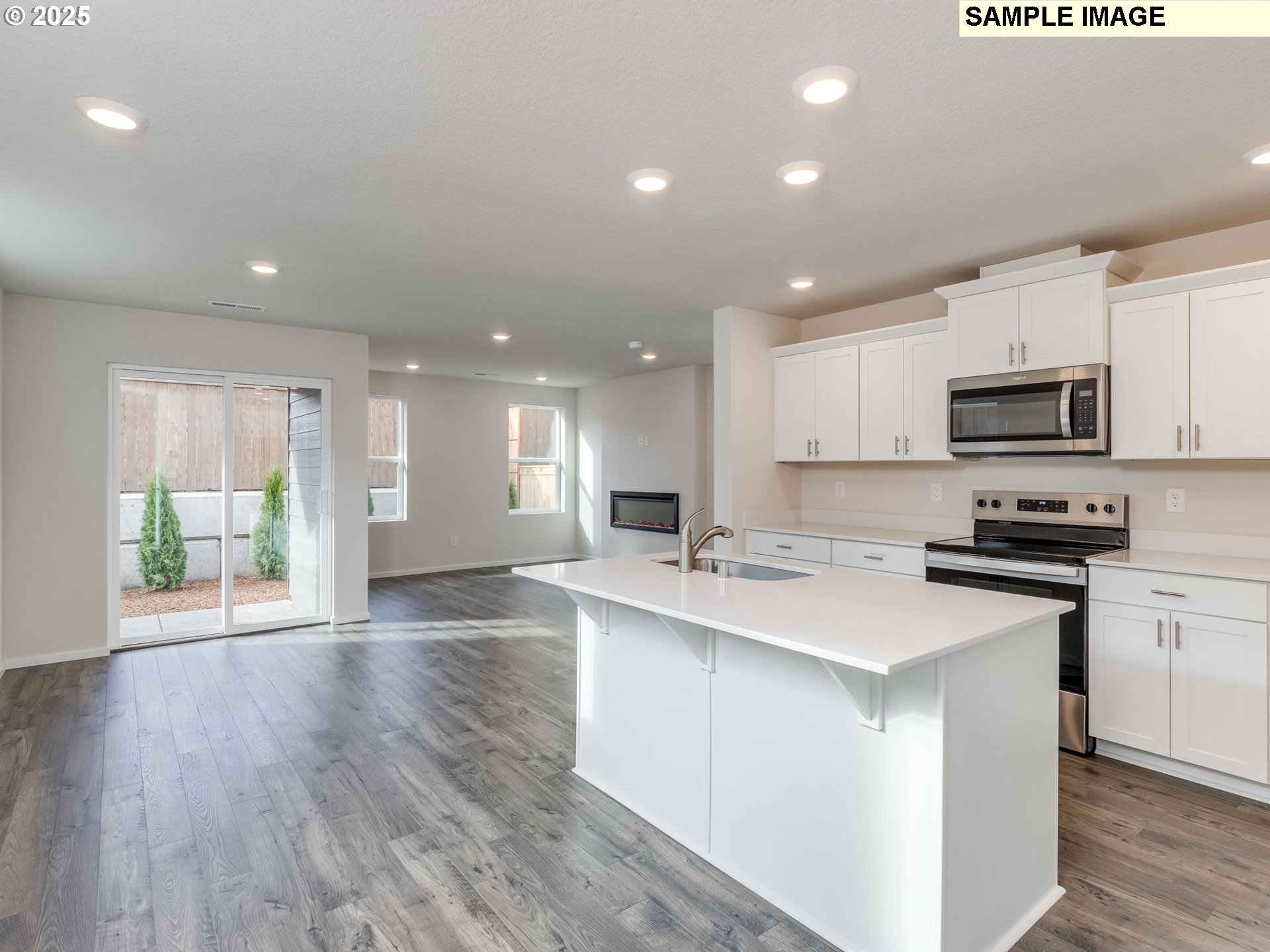 19308 Southeast 11th Way Camas, WA 98607 - Photo 3 of 28 a kitchen with stainless steel appliances granite countertop a sink a stove a microwave a refrigerator with white cabinets and wooden floor