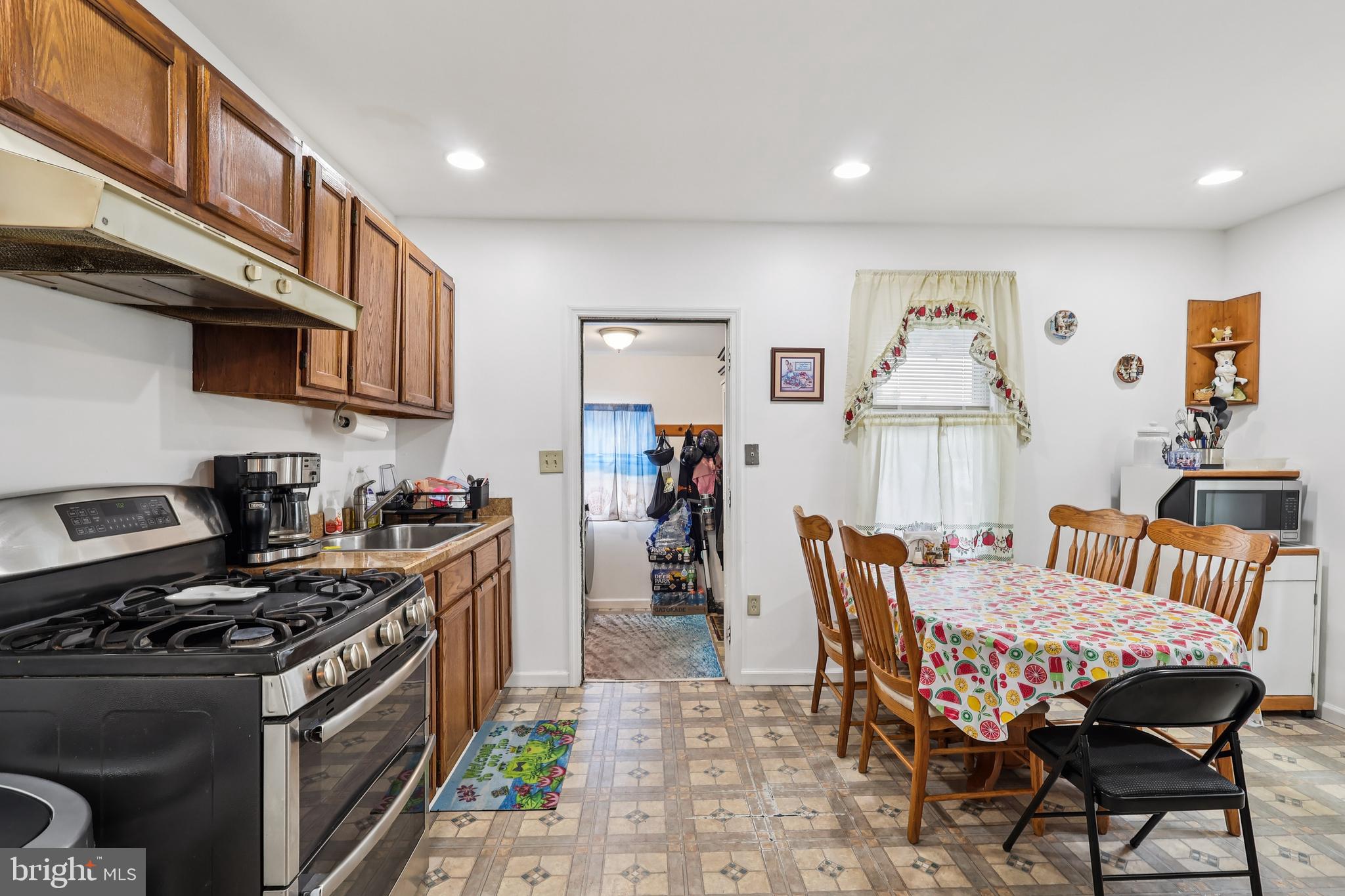 305 Filmore Street Riverside, NJ 08075 - Photo 10 of 32 a kitchen with stainless steel appliances granite countertop a stove top oven a sink a dining table and chairs
