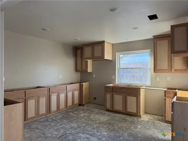 a kitchen with cabinets and window