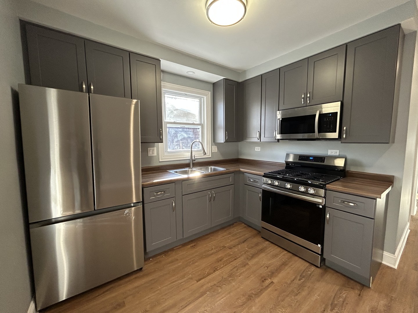 2717 North Rutherford Avenue, Unit 2 Chicago, IL 60707 - Photo 2 of 10 a kitchen with granite countertop stainless steel appliances and wooden cabinets