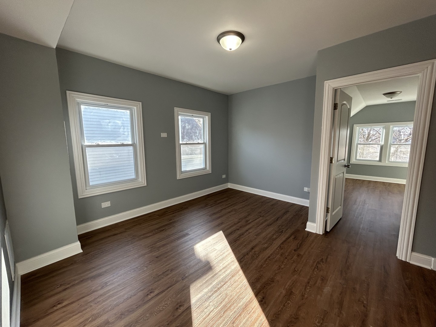 2717 North Rutherford Avenue, Unit 2 Chicago, IL 60707 - Photo 4 of 10 an empty room with wooden floor and windows