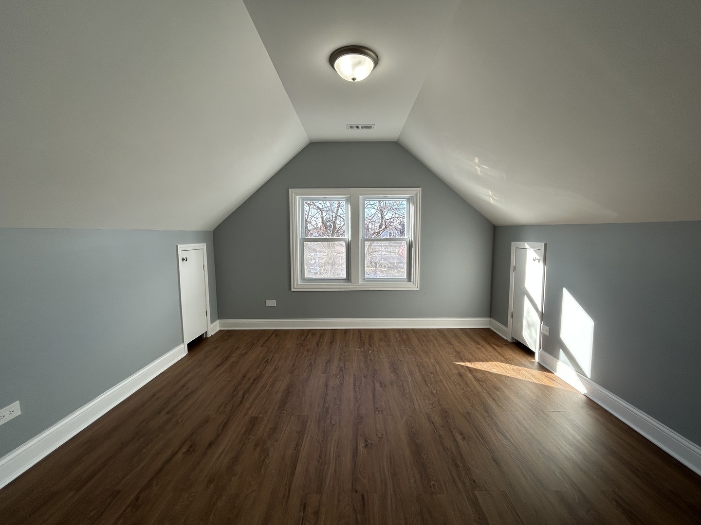 2717 North Rutherford Avenue, Unit 2 Chicago, IL 60707 - Photo 6 of 10 an empty room with wooden floor and windows