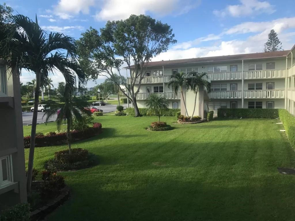21 Dorset A Boca Raton, FL 33434 - Photo 5 of 7 a view of a building with a big yard and large trees