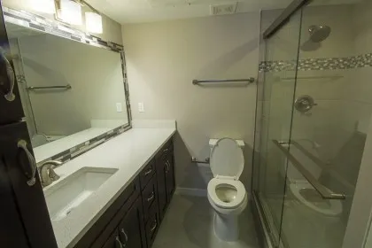 a bathroom with a granite countertop sink toilet and shower