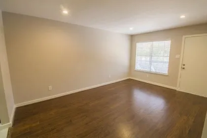 an empty room with wooden floor and window