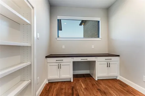 a room with a wooden floor and cabinets