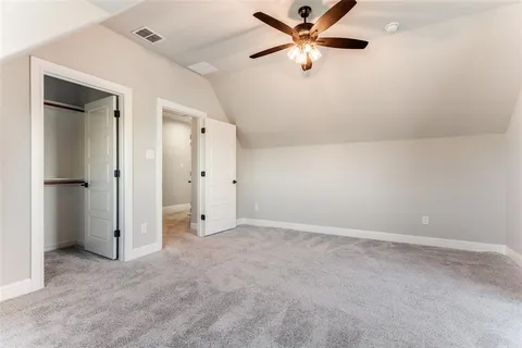 an empty room with closet and a ceiling fan