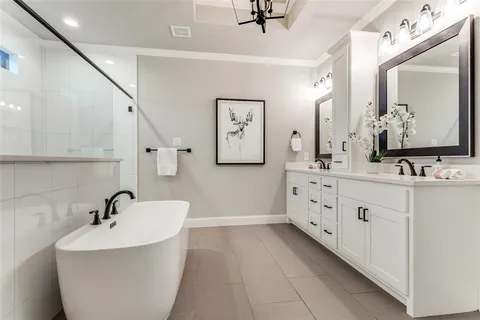 a bathroom with a double vanity sink mirror and bathtub