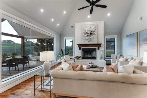 a living room with furniture a fireplace and a floor to ceiling window