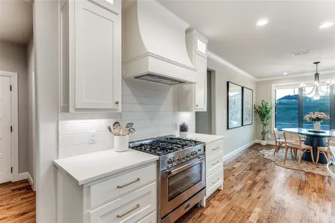 a kitchen that has a stove and a wooden floor