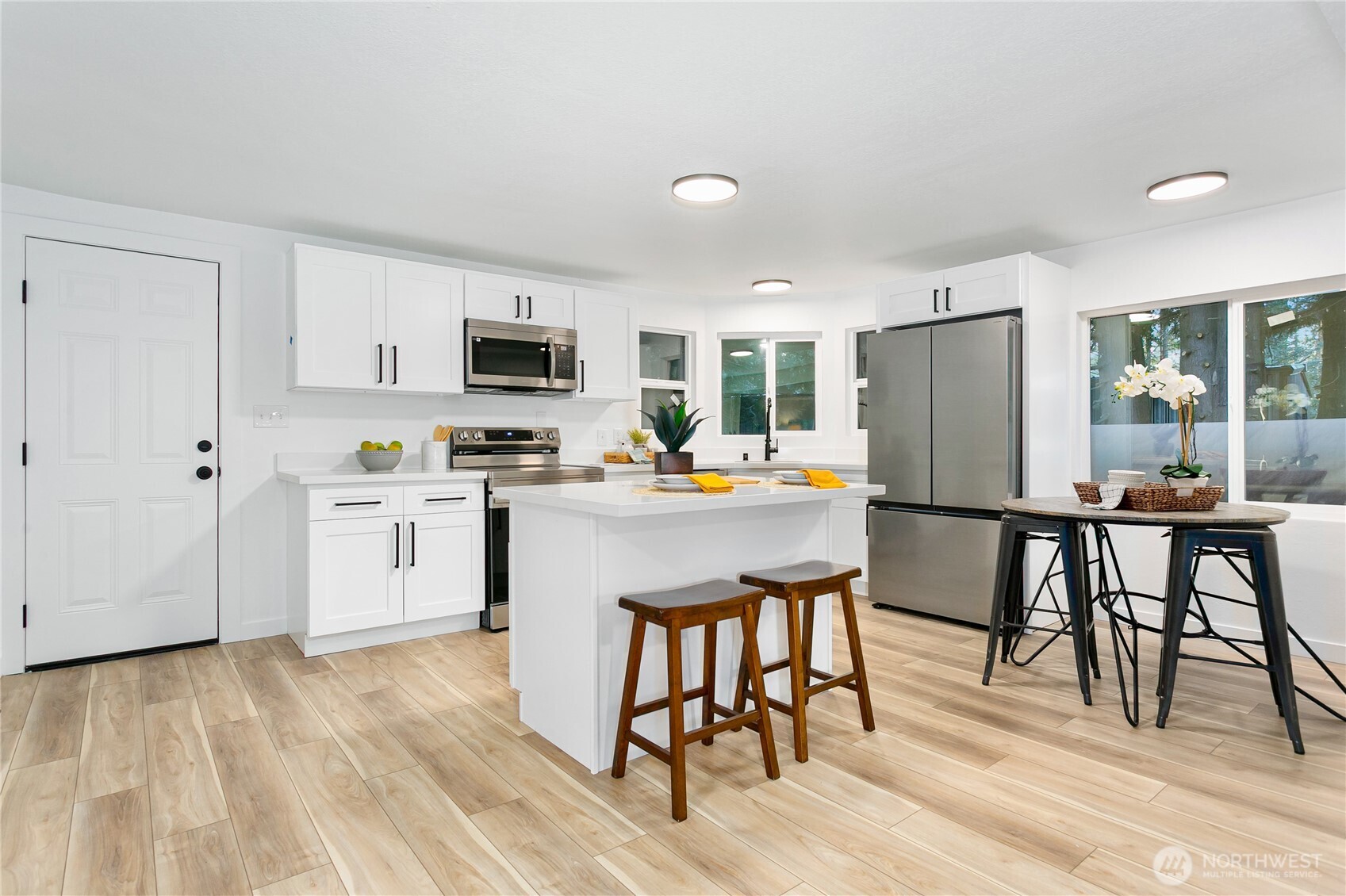 8021 Northeast Eglon Road Kingston, WA 98346 - Photo 7 of 35 a kitchen with stainless steel appliances white cabinets and wooden floor